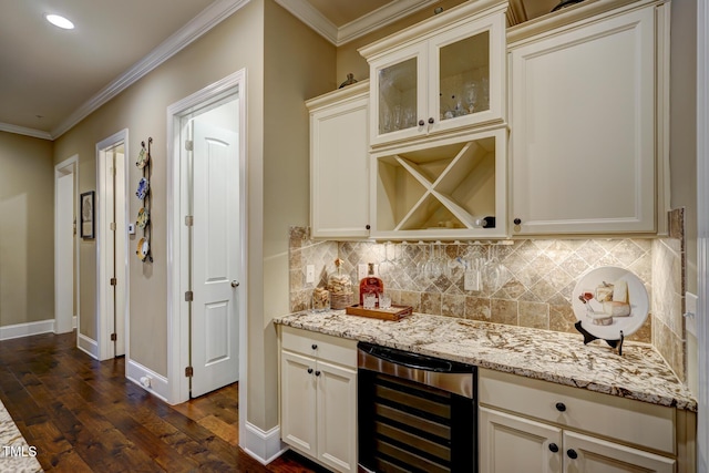 bar featuring decorative backsplash, crown molding, dark wood finished floors, a bar, and beverage cooler