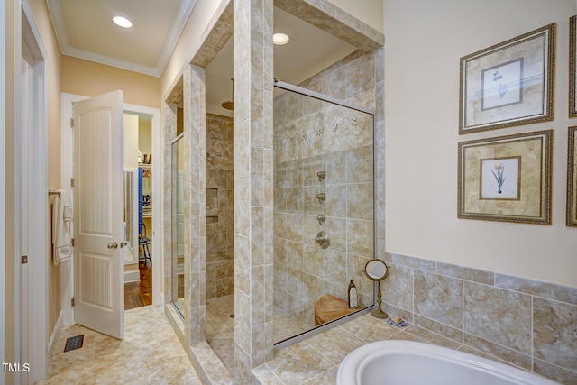 bathroom with visible vents, a bath, a stall shower, and ornamental molding