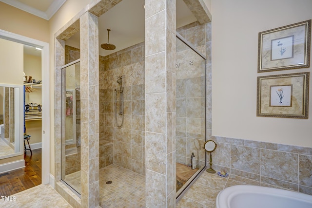 bathroom with ornamental molding, a walk in closet, a bath, and a stall shower