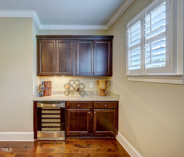 bar featuring baseboards, a bar, dark wood finished floors, and beverage cooler