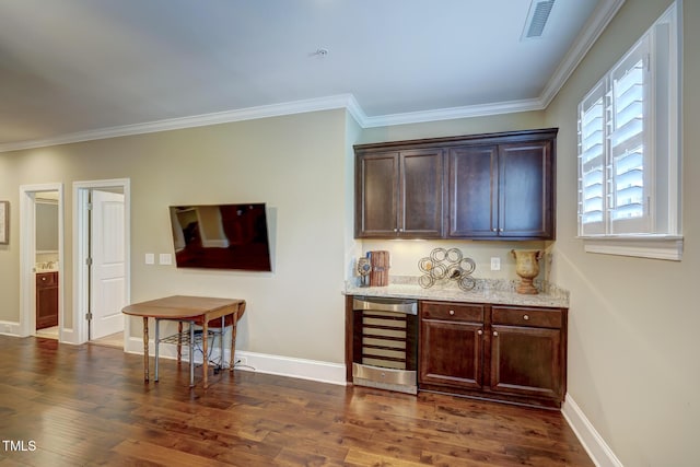 bar with beverage cooler, dark wood-type flooring, and crown molding