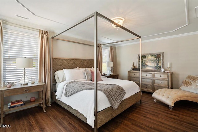 bedroom with ornamental molding, wood finished floors, and visible vents