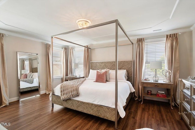 bedroom featuring crown molding, baseboards, dark wood finished floors, and visible vents