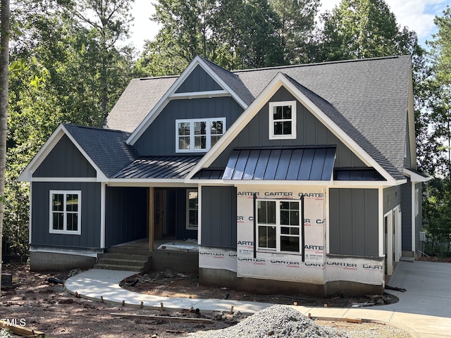 485 Chapel Ridge Dr, Pittsboro, NC 27312 - view of front facade featuring a standing seam roof, a shingled roof, a porch, and a metal roof