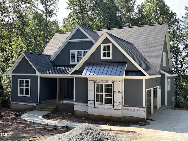 485 Chapel Ridge Dr, Pittsboro, NC 27312 - view of front of house featuring a standing seam roof, a shingled roof, a porch, a metal roof, and board and batten siding
