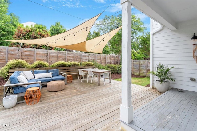deck with outdoor dining space and a fenced backyard