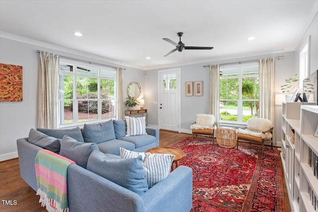 living area featuring baseboards, ornamental molding, and wood finished floors
