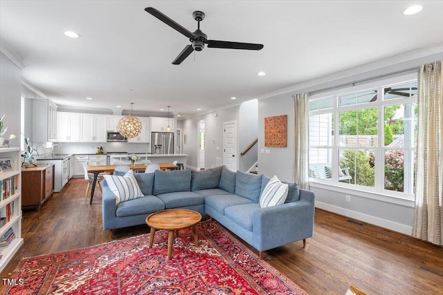 living area with dark wood finished floors, recessed lighting, ornamental molding, ceiling fan, and visible vents
