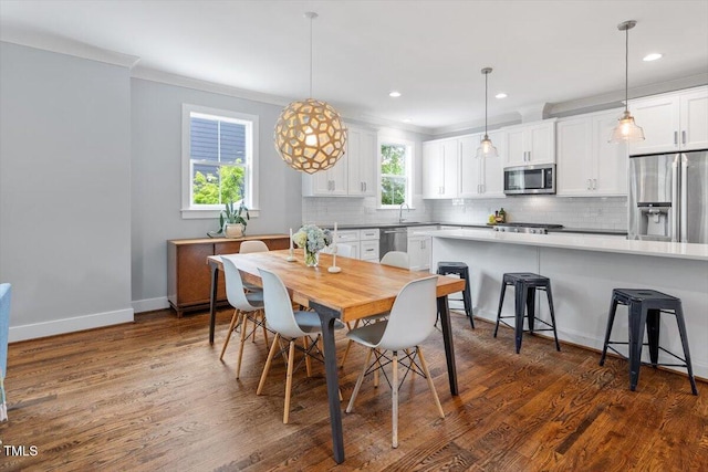 dining space featuring dark wood finished floors, baseboards, ornamental molding, and recessed lighting
