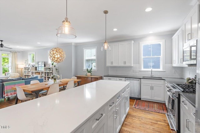 kitchen with appliances with stainless steel finishes, backsplash, crown molding, and a sink