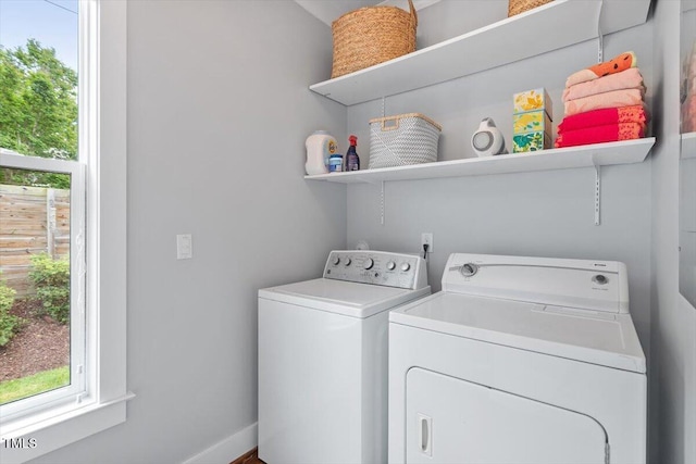 laundry area featuring baseboards, a healthy amount of sunlight, separate washer and dryer, and laundry area