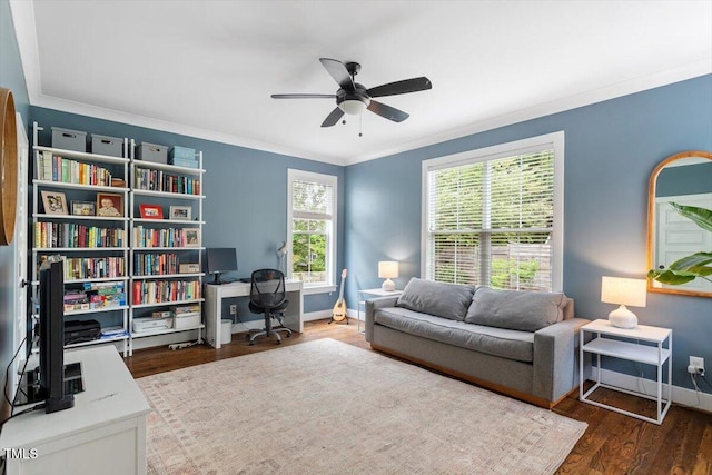 sitting room with wood finished floors, a ceiling fan, ornamental molding, and baseboards