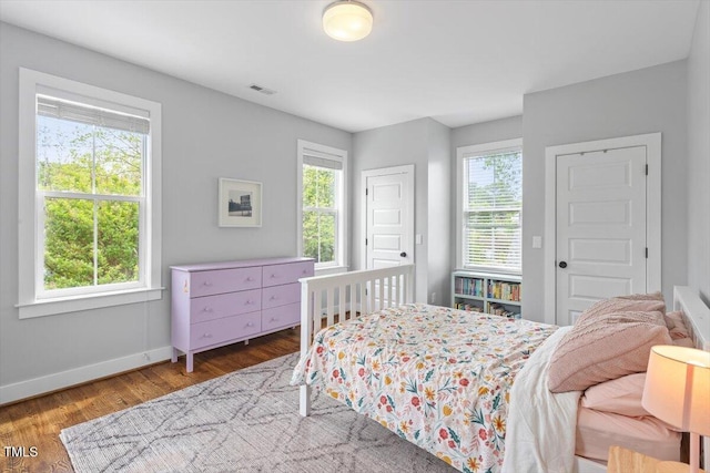 bedroom featuring visible vents, wood finished floors, and baseboards