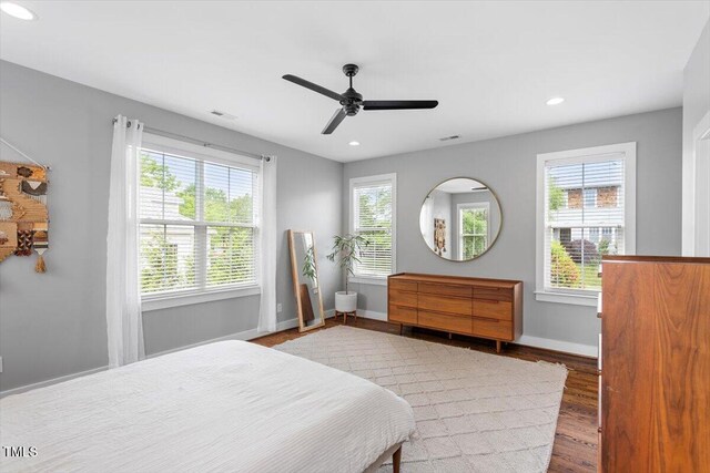 bedroom featuring recessed lighting, multiple windows, wood finished floors, and baseboards
