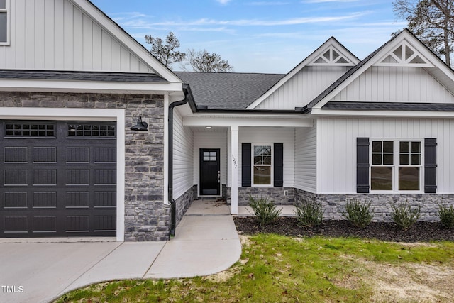3803 Huntcliff Dr, La Grange, NC 28551 - doorway to property with stone siding, board and batten siding, roof with shingles, an attached garage, and covered porch