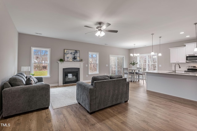 3803 Huntcliff Dr, La Grange, NC 28551 - living room featuring wood finished floors, a glass covered fireplace, a ceiling fan, plenty of natural light, and recessed lighting