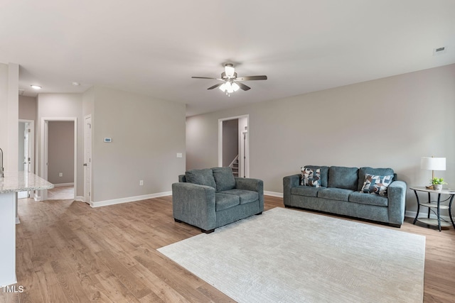 3803 Huntcliff Dr, La Grange, NC 28551 - living area with stairway, a ceiling fan, light wood finished floors, and baseboards