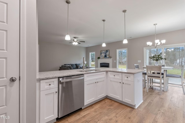3803 Huntcliff Dr, La Grange, NC 28551 - kitchen featuring stainless steel dishwasher, a sink, a fireplace, ceiling fan, and light wood-style flooring