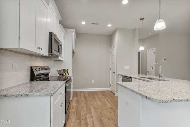 3803 Huntcliff Dr, La Grange, NC 28551 - kitchen featuring appliances with stainless steel finishes, a sink, white cabinets, light wood-style flooring, and backsplash