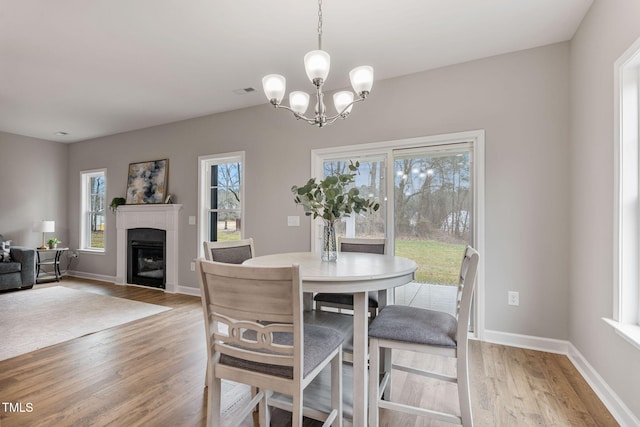 3803 Huntcliff Dr, La Grange, NC 28551 - dining area with light wood finished floors, a chandelier, a fireplace, and baseboards