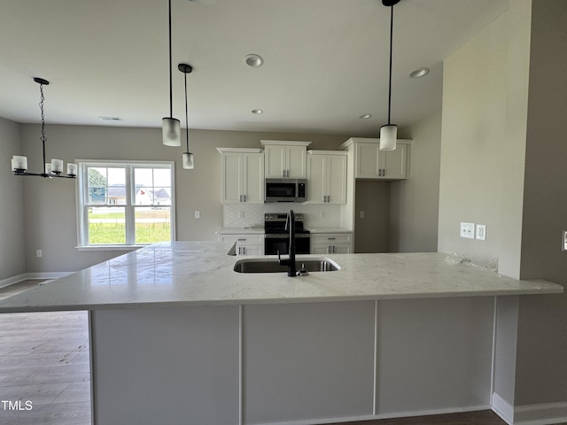 3803 Huntcliff Dr, La Grange, NC 28551 - kitchen featuring appliances with stainless steel finishes, white cabinetry, light stone countertops, backsplash, and wood finished floors