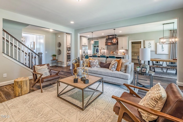 living area with recessed lighting, stairs, wood finished floors, and baseboards