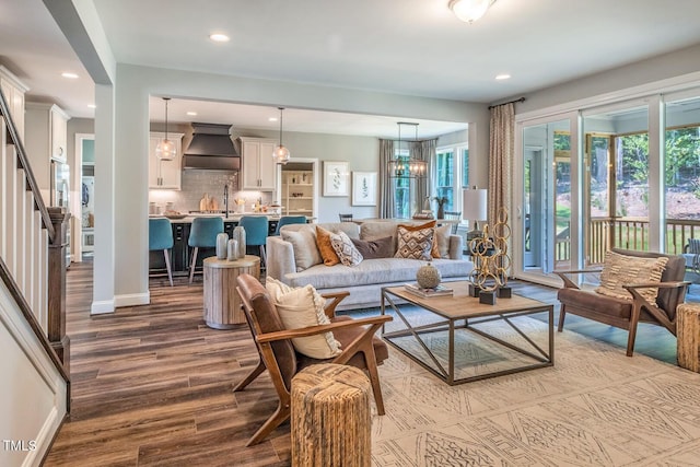 living room featuring dark wood-type flooring, recessed lighting, and stairs