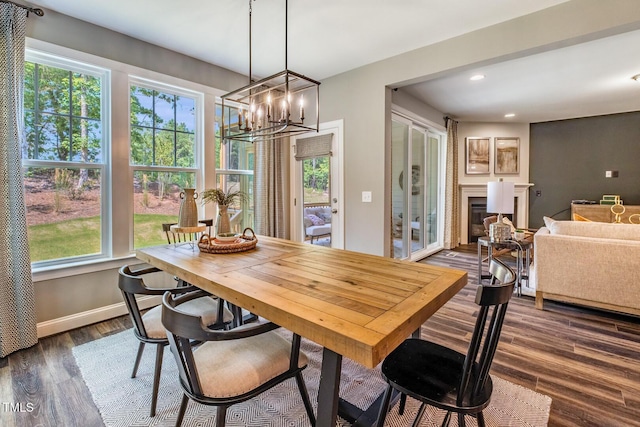 dining room with recessed lighting, an inviting chandelier, dark wood-style flooring, a glass covered fireplace, and baseboards