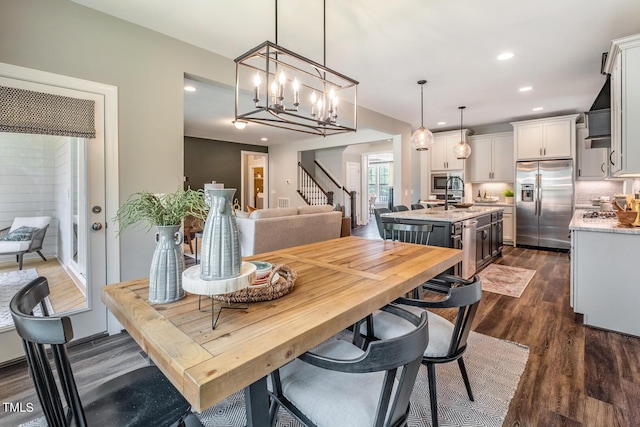dining area with dark wood-style floors, recessed lighting, a chandelier, and stairway