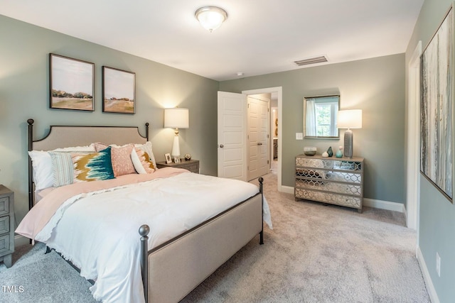 bedroom with baseboards, visible vents, and light colored carpet
