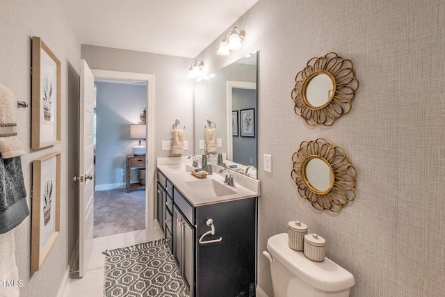 bathroom featuring toilet, double vanity, and a sink