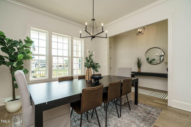 dining area with ornamental molding, a notable chandelier, wood finished floors, and baseboards