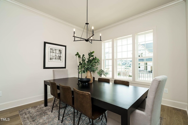 dining room featuring crown molding, dark wood-style floors, a notable chandelier, and baseboards