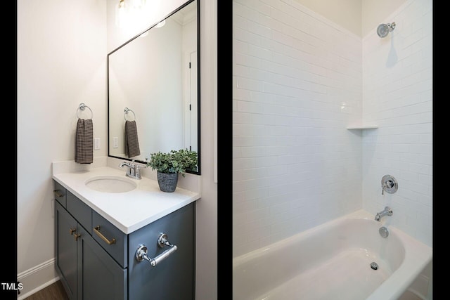 full bath with baseboards, washtub / shower combination, and vanity