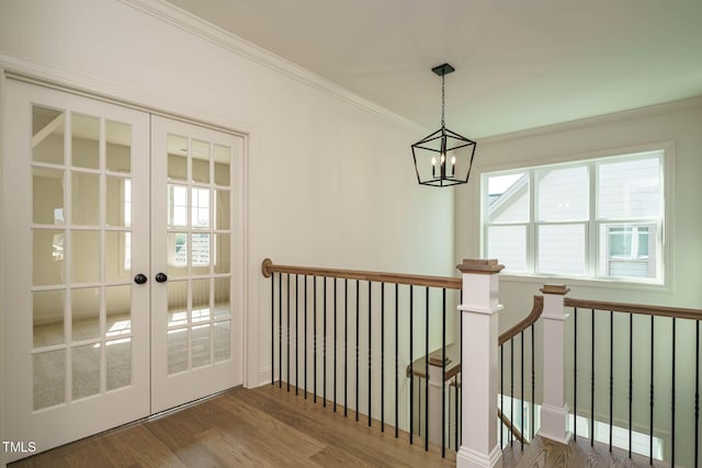 entryway with wood finished floors, a chandelier, french doors, and ornamental molding