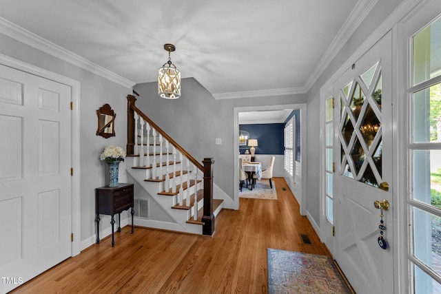 2409 Beechview Ct, Raleigh, NC 27615 - foyer with stairs, light wood-style flooring, a chandelier, baseboards, and crown molding