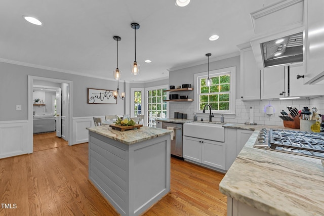 2409 Beechview Ct, Raleigh, NC 27615 - kitchen featuring stainless steel appliances, a sink, crown molding, a kitchen island, and open shelves