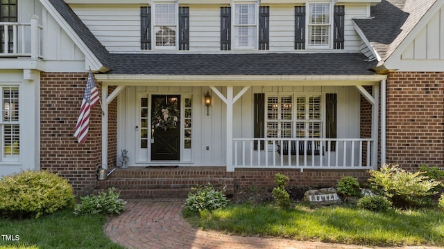 2409 Beechview Ct, Raleigh, NC 27615 - doorway to property featuring board and batten siding, brick siding, roof with shingles, and a porch
