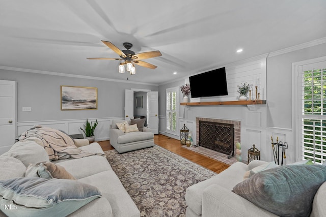 2409 Beechview Ct, Raleigh, NC 27615 - living area with plenty of natural light, a ceiling fan, a fireplace, wood finished floors, and crown molding