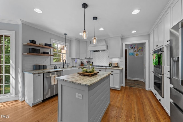 2409 Beechview Ct, Raleigh, NC 27615 - kitchen featuring stainless steel appliances, premium range hood, tasteful backsplash, crown molding, and a center island