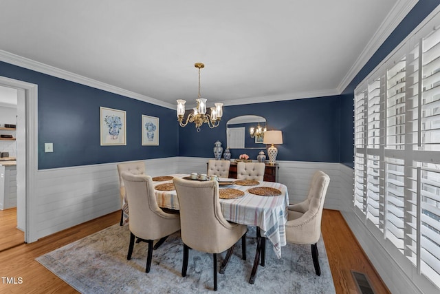 2409 Beechview Ct, Raleigh, NC 27615 - dining room featuring a wainscoted wall, a chandelier, crown molding, and wood finished floors