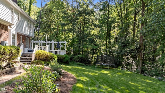 2409 Beechview Ct, Raleigh, NC 27615 - view of green lawn featuring a trampoline, a deck, and stairway