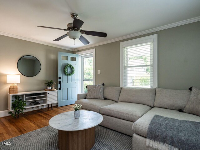 living room featuring crown molding, a ceiling fan, baseboards, and wood finished floors