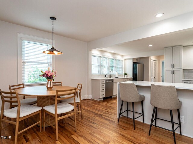 dining area featuring recessed lighting, baseboards, and light wood-style flooring