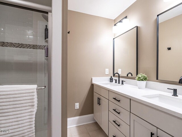 bathroom with tile patterned flooring, a sink, and a stall shower