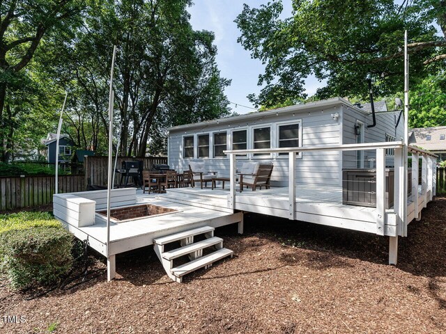 back of property with fence and a deck