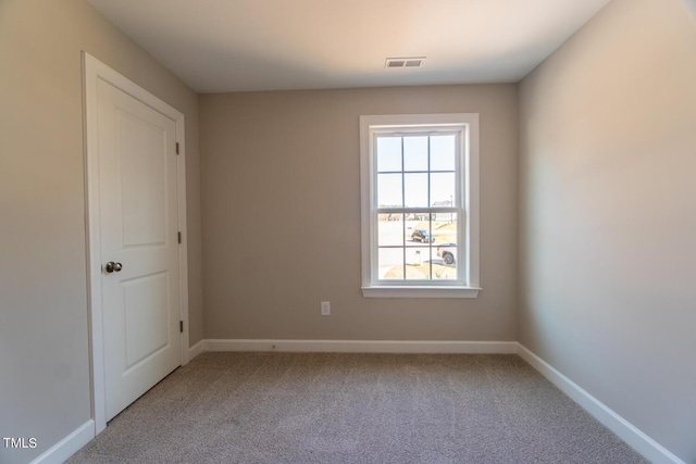 carpeted empty room featuring visible vents and baseboards