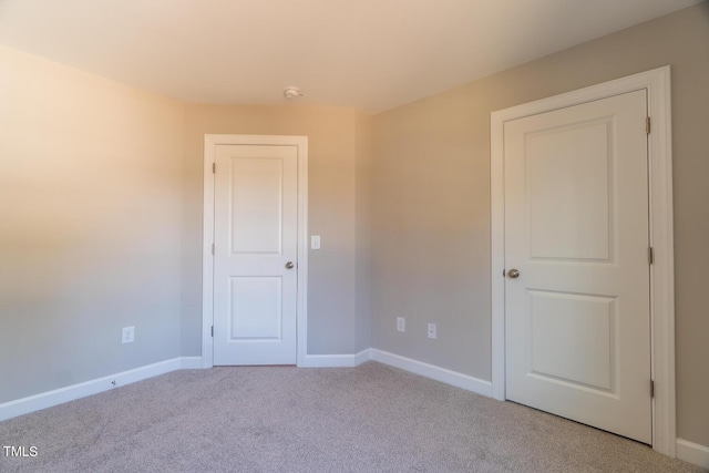 carpeted empty room with baseboards