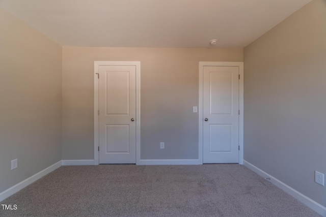 unfurnished room with baseboards and carpet