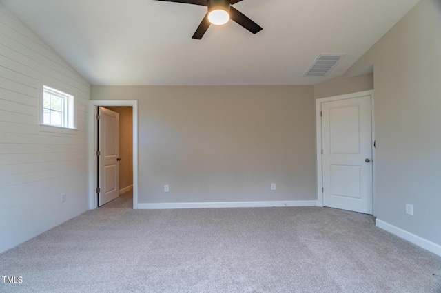 carpeted empty room featuring vaulted ceiling, visible vents, baseboards, and ceiling fan